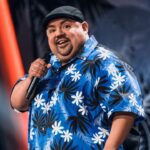 Comedian Gabriel Iglesias holding a mic while performing on his comedy special
